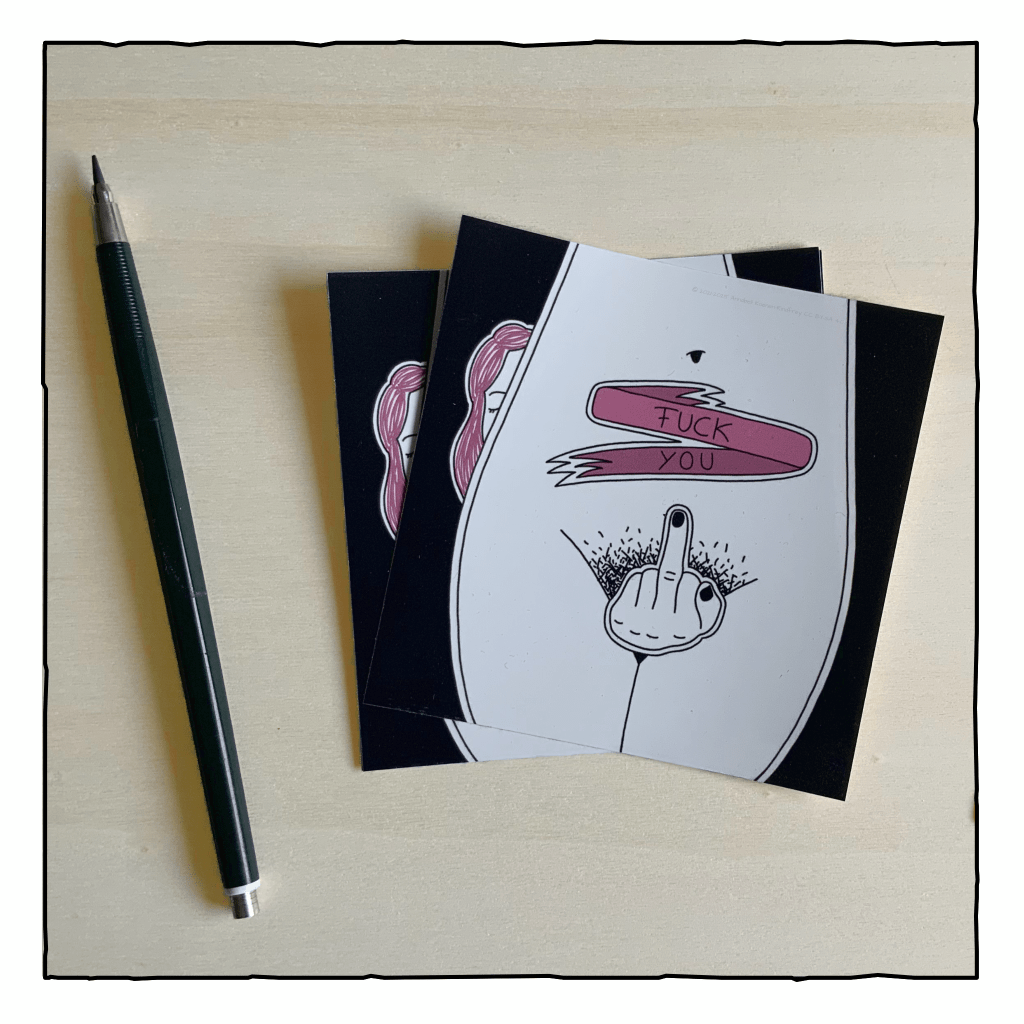 Sticker auf einem Holzbrett. Eine Zeichnung zeigt eine Hüfte einer Person mit Vulva. Der Intimbereich ist mit einem Mittelfinger zensiert. Eine Person mit pinken Haaren schaut hinter der Hüfte hervor. Ein pinkes Band über dem Bauchnabel trägt die Aufschrift Fuck You. Die gesamte Zeichnung ist in schwarz und weiß gehalten, das Band und die Haare sind pink.